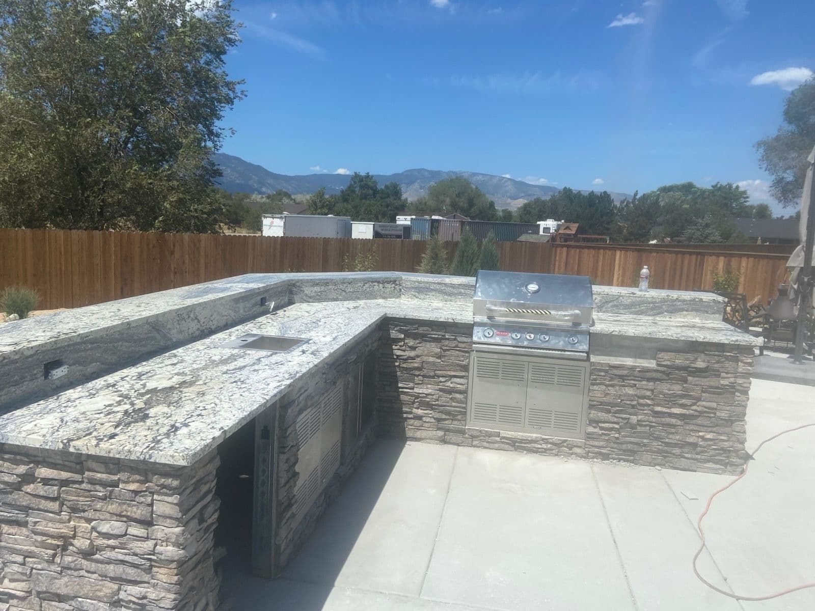 Stunning Outdoor Kitchen with Stone and Granite image